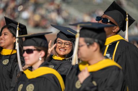 A graduate smiles at the camera